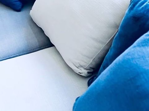 Un sofá con almohadas azules y blancas.