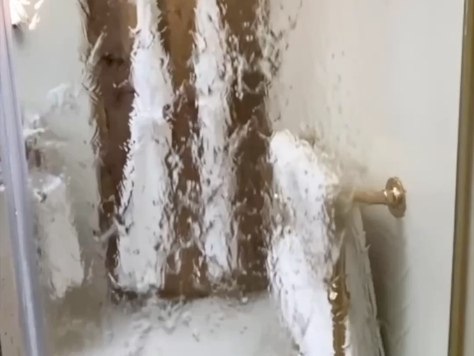 Una cabina de ducha de la que sale mucha espuma.