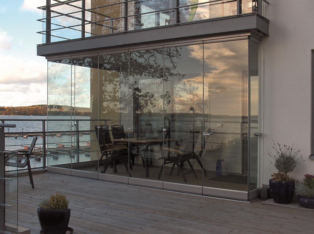 Petite terrasse vitrifiée à côté d'un grand balcon ouvert