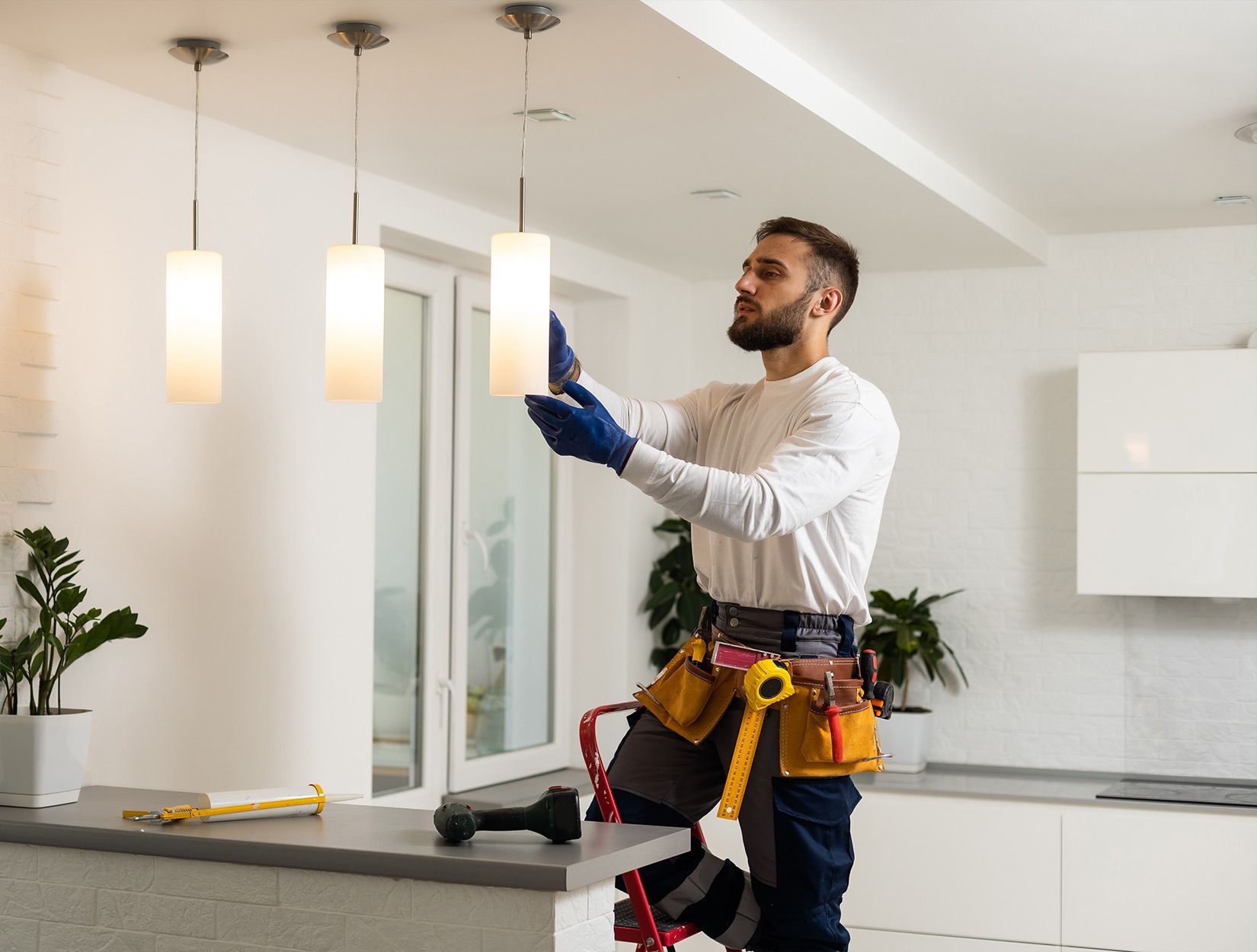 Employé posant un luminaire au plafond 