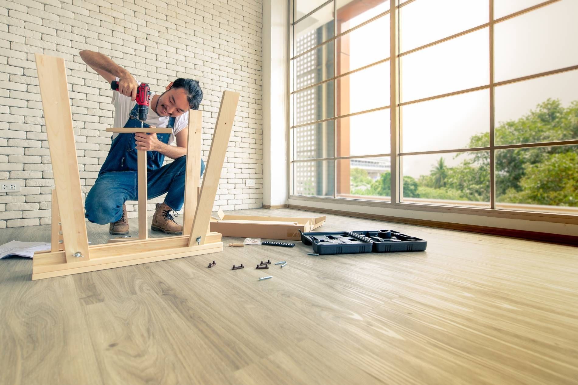 Un hombre está trabajando en una mesa de madera en una habitación.