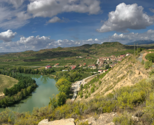 Un río que fluye por un valle con montañas al fondo.
