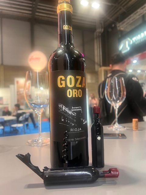 Una botella de vino goza oro reposa sobre una mesa.