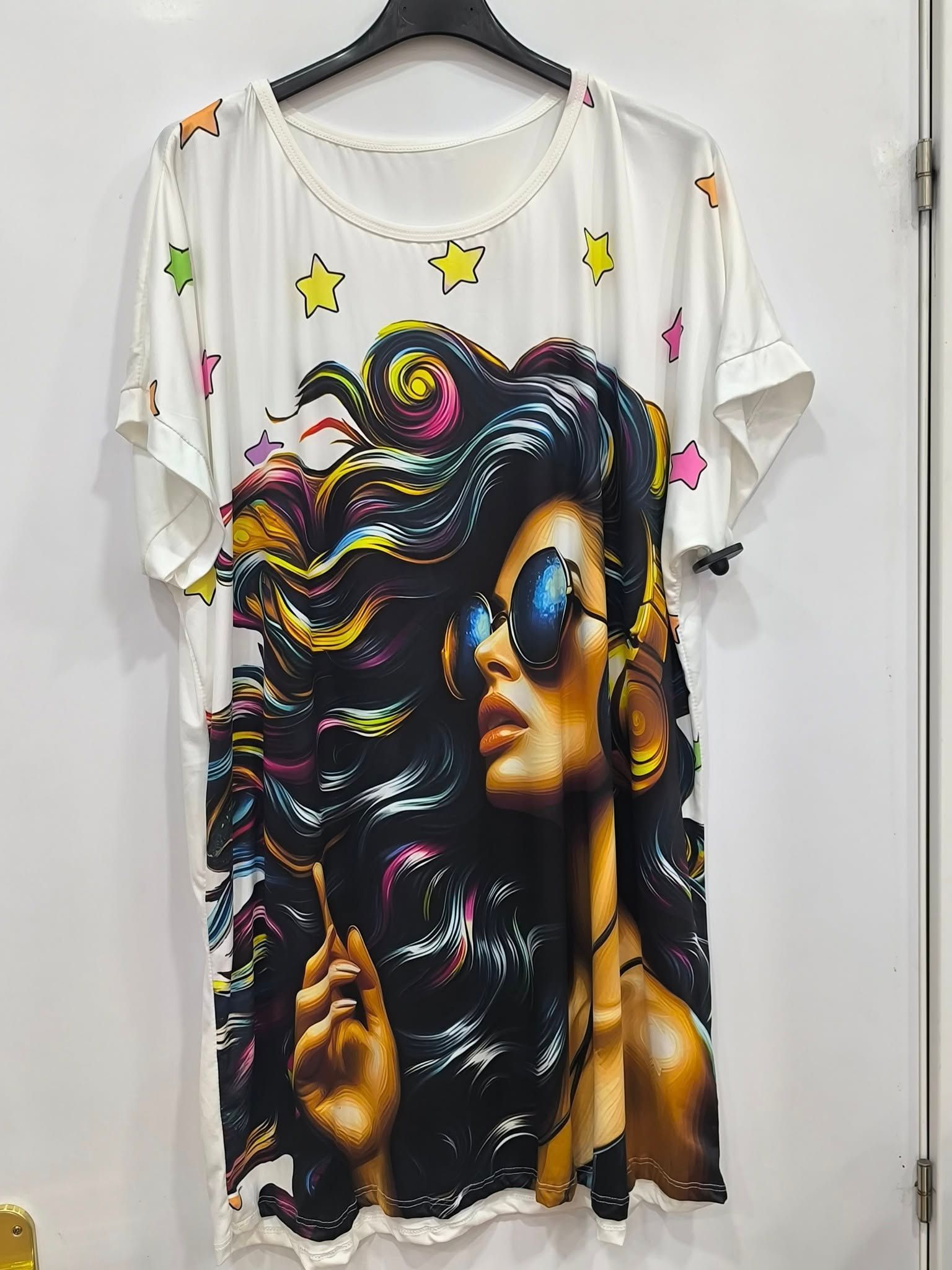 Una camiseta blanca con la cara de una mujer está colgada en una percha.