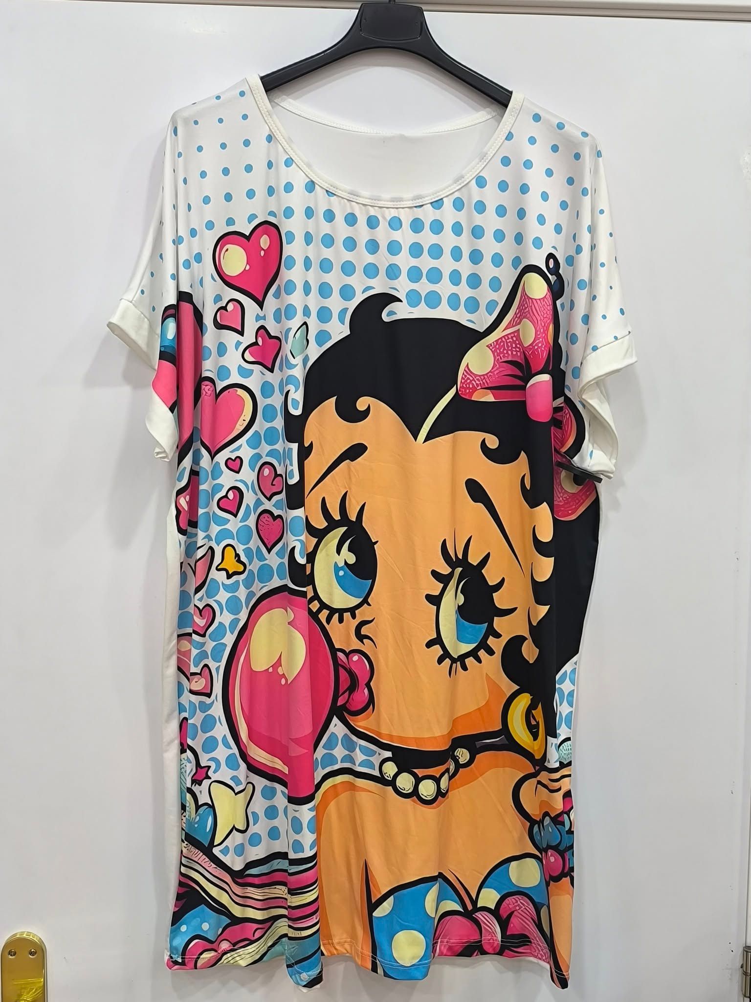 Una camiseta con Betty Boop está colgada en una percha.