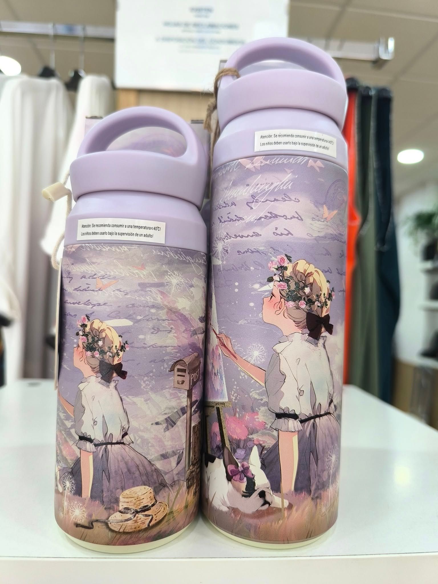 Dos botellas con la imagen de una niña están sobre una mesa.