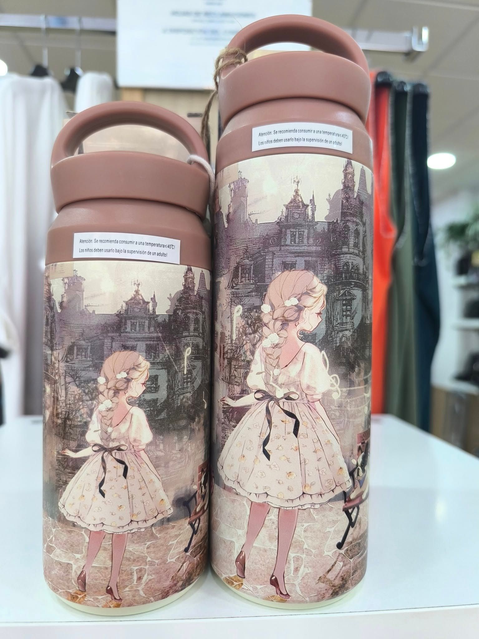 Dos botellas con la imagen de una niña están sobre una mesa.