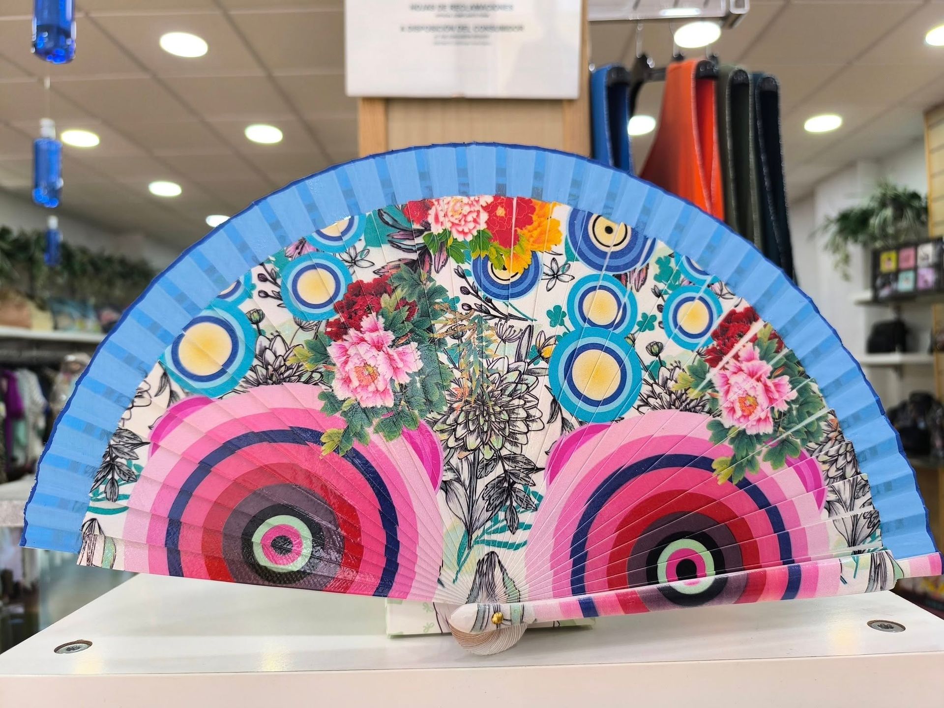 Un abanico colorido está sobre una mesa en una tienda.