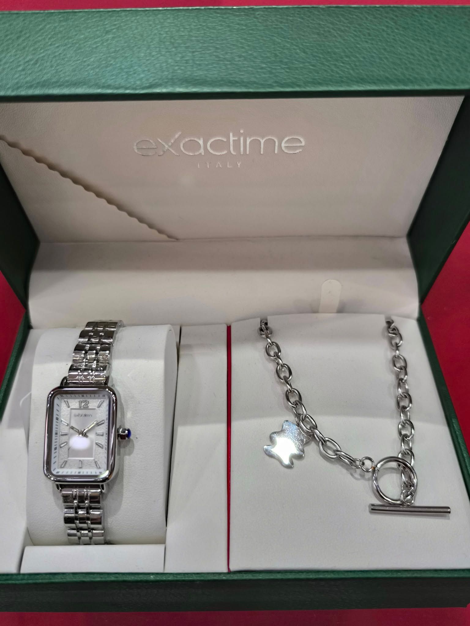 Un reloj y un collar en una caja que dice hora exacta