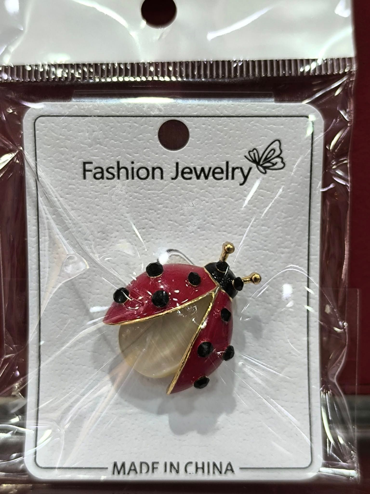 Un broche de mariquita está envuelto en plástico y está hecho en China.