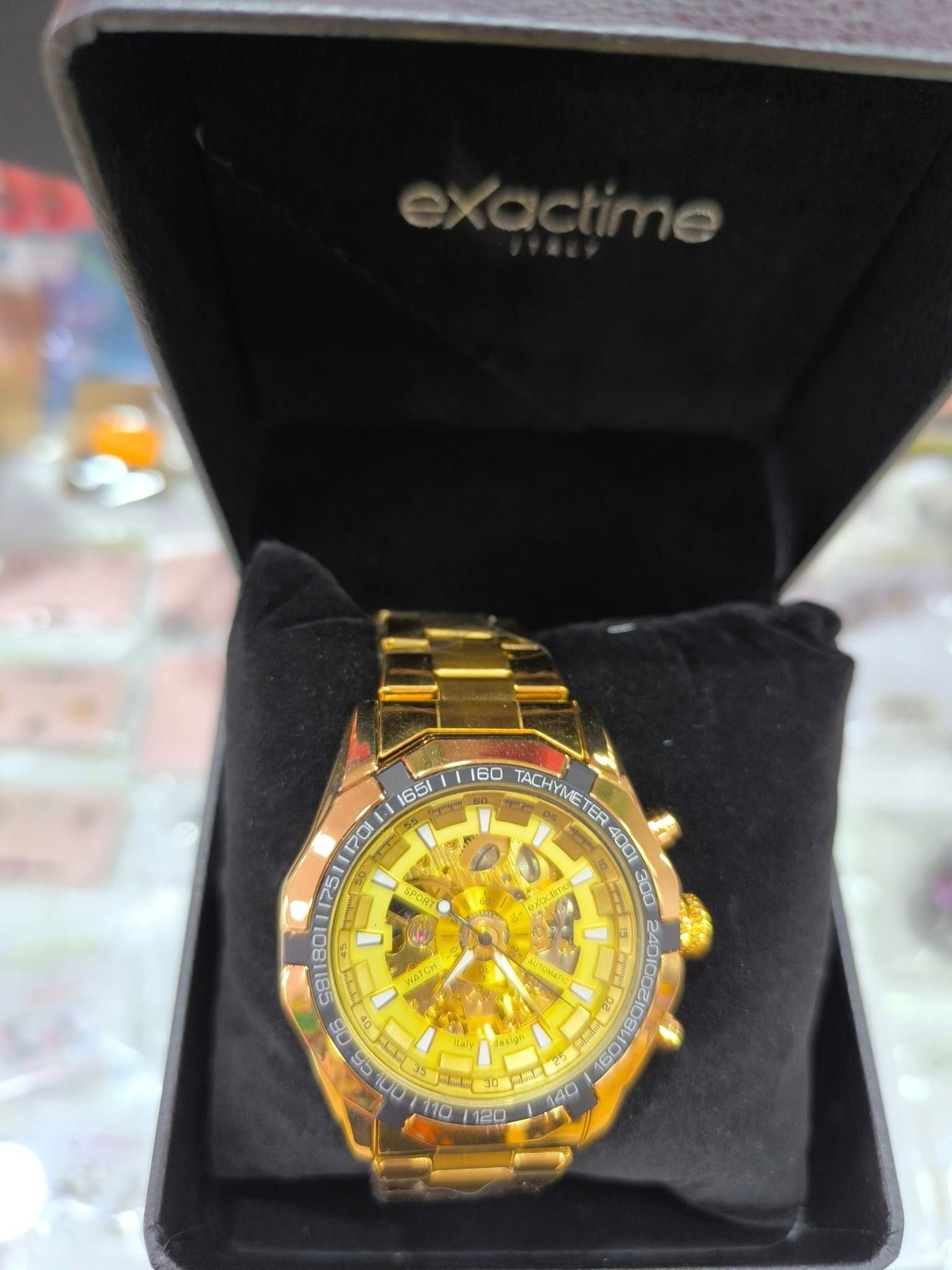 Un reloj de oro en una caja negra que dice hora exacta