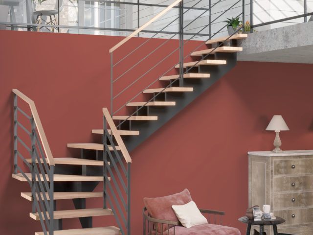 Escalier vers une mezzanine devant un mur terre rouge