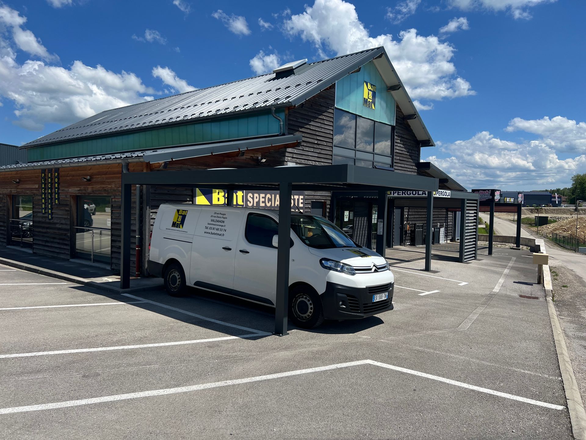 Camion blanc Bat & Mat sous un carport noir