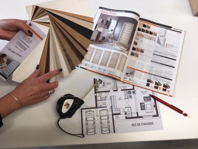 Plan et catalogue ouvert posés sur la table.