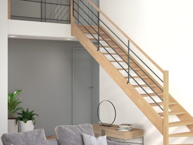 Escalier vers une mezzanine devant un mur gris et blanc