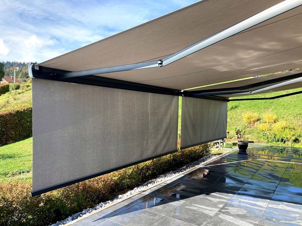 Deux stores ouvert protégeant une terrasse du soleil.