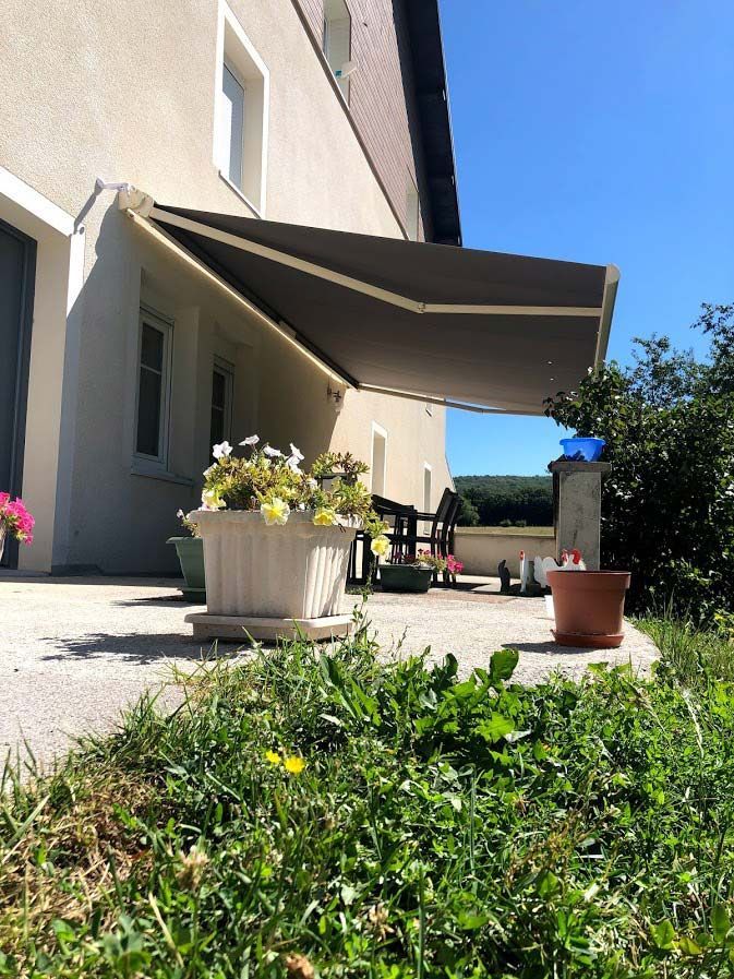Store banne rouge sur une façade rouge et verte.