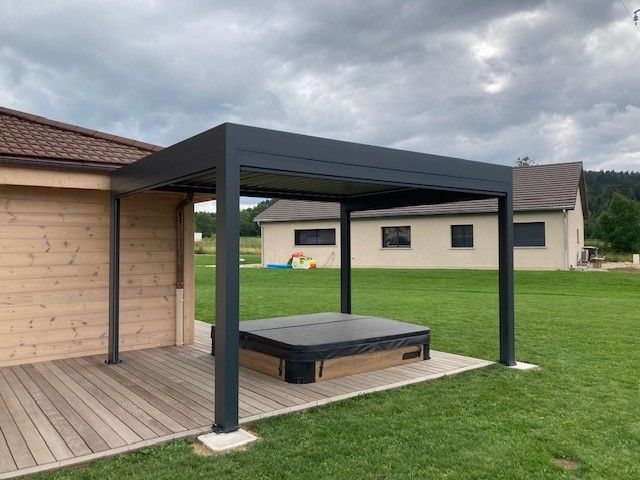 Pergola à côté d'une maison en bois.