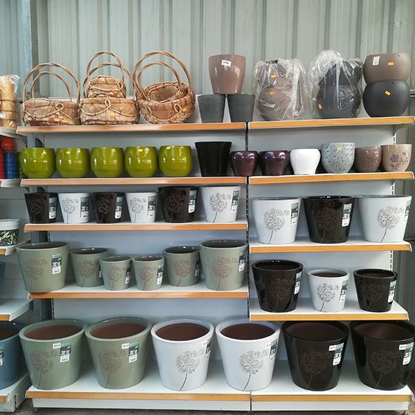 Un estante de una tienda lleno de macetas y cestas.