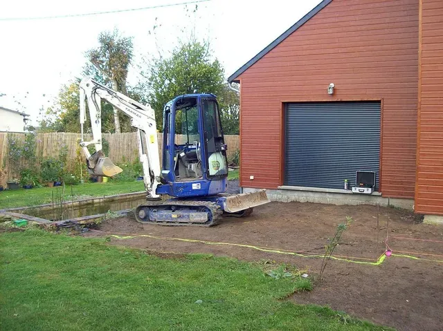 Tractopelle creusant un trou pour un bassin