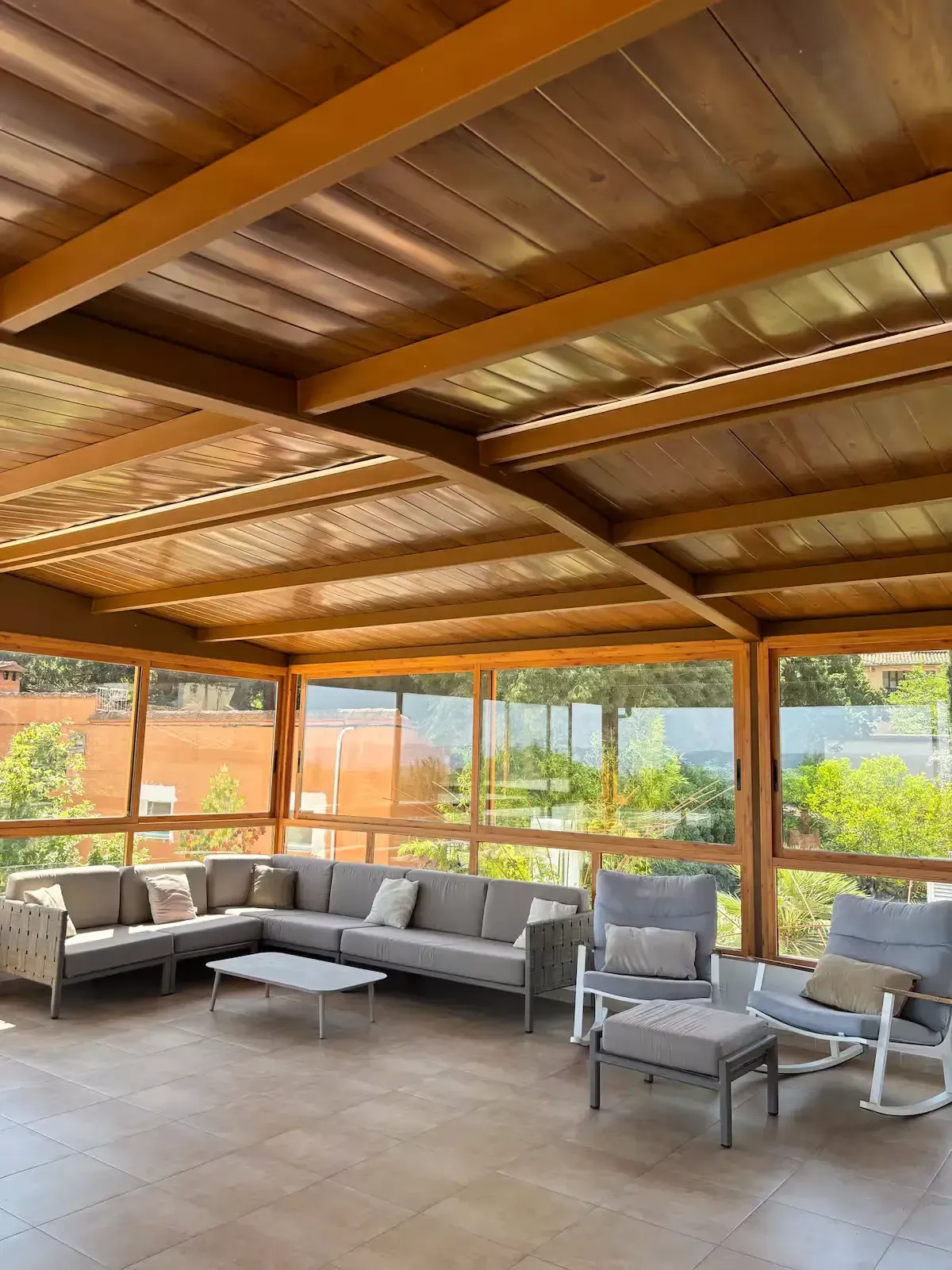Vista de una zona de piscina con un cielo azul despejado, edificios y árboles verdes. 