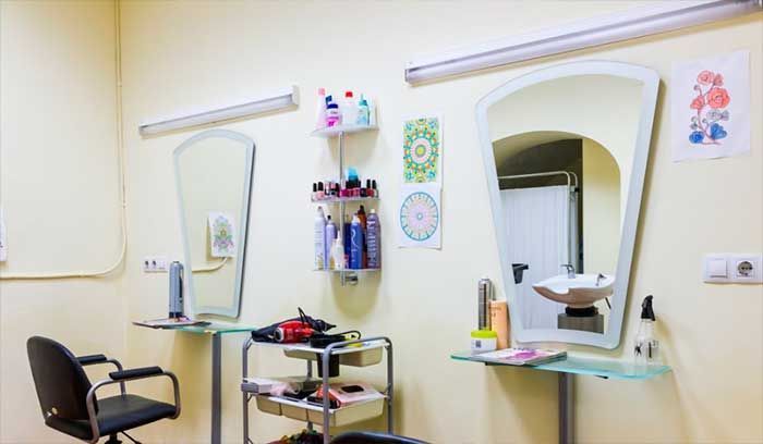 Una peluquería con dos sillas y dos espejos.