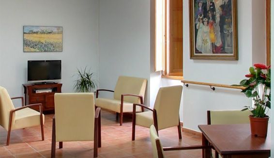 Una sala de estar con sillas, una mesa y un televisor.