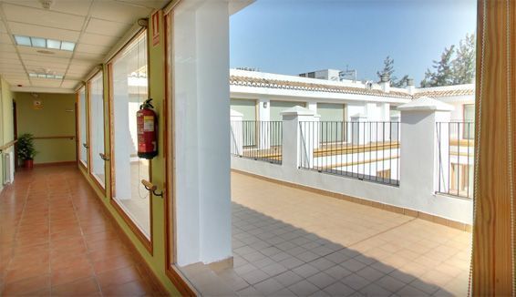 Un largo pasillo con un extintor colgado en la pared.