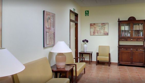 Una sala de estar con un sofá, sillas, una lámpara y un armario.