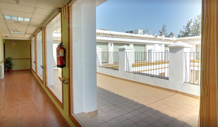 Un largo pasillo con un extintor colgado en la pared.