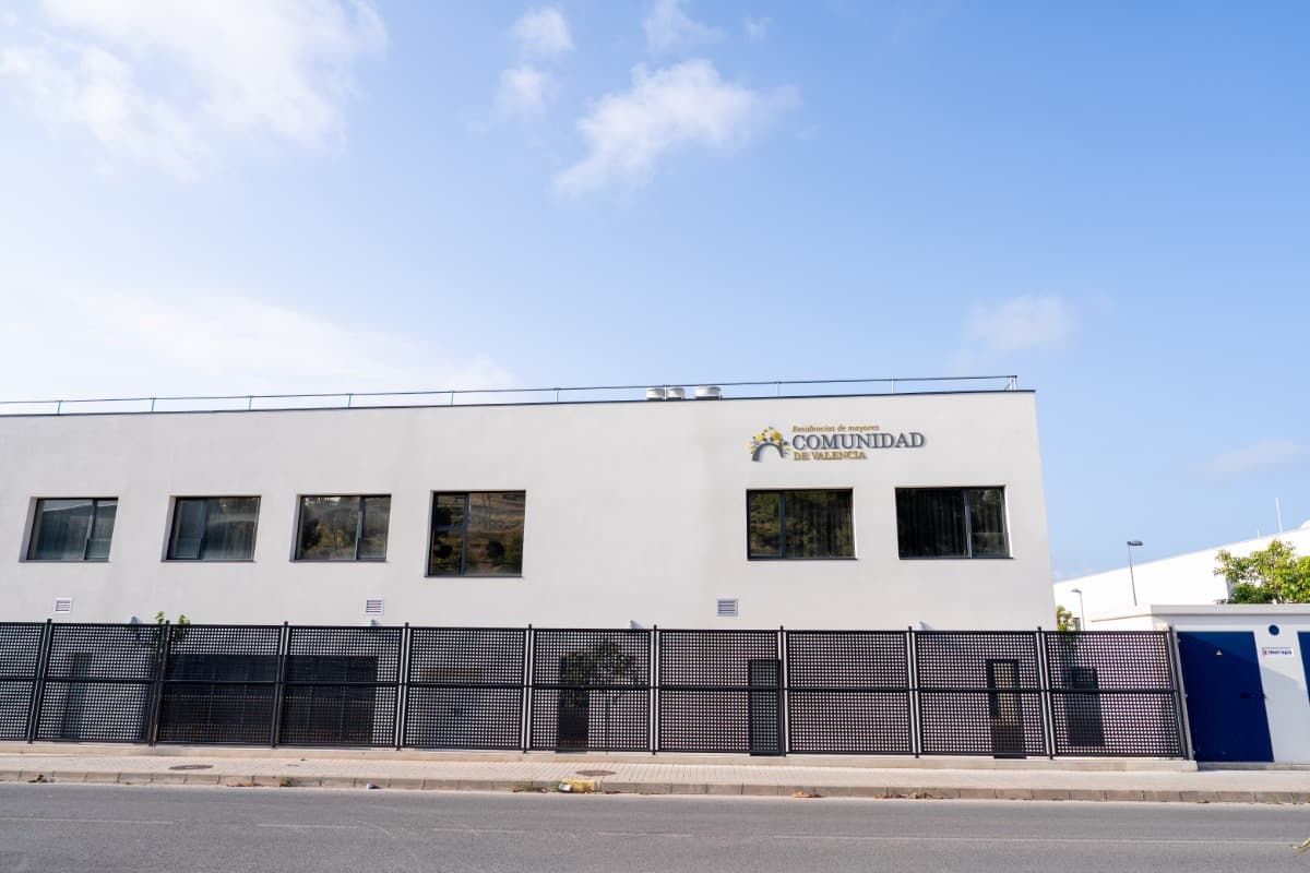 Edificio blanco con valla negra; logo