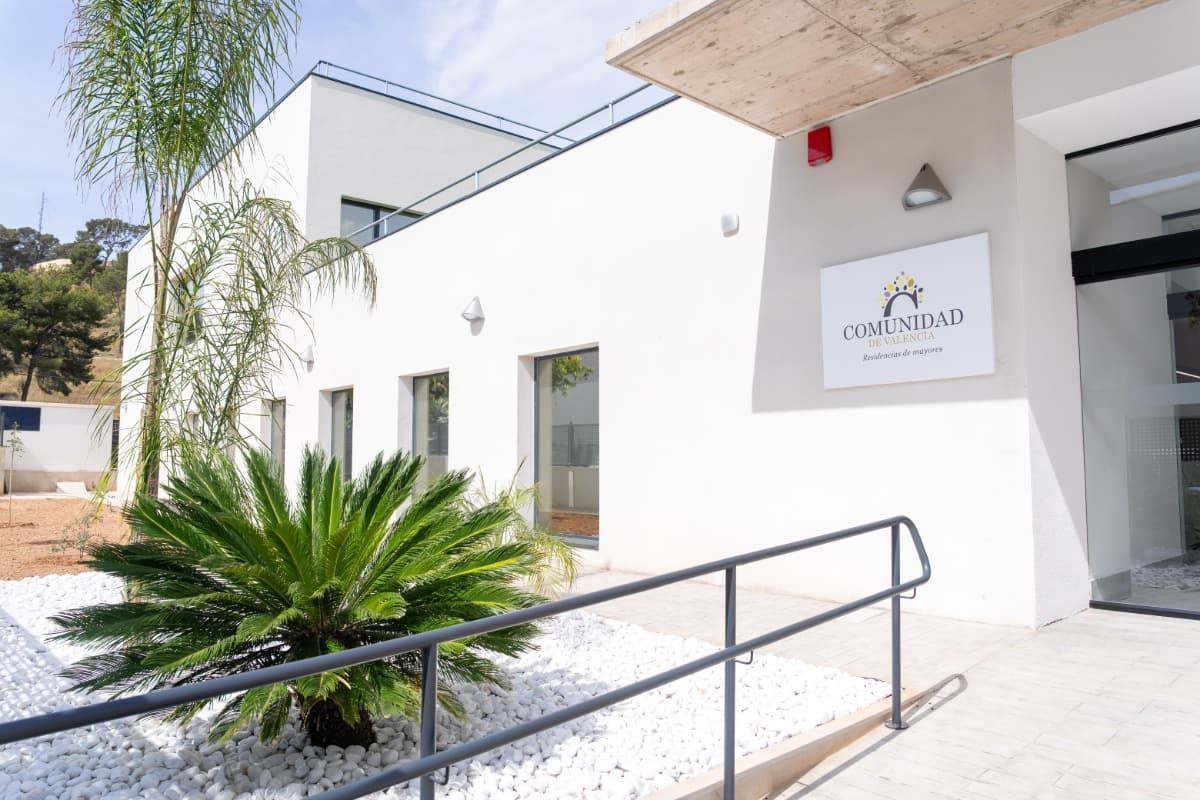 Exterior de un edificio blanco con un cartel que dice