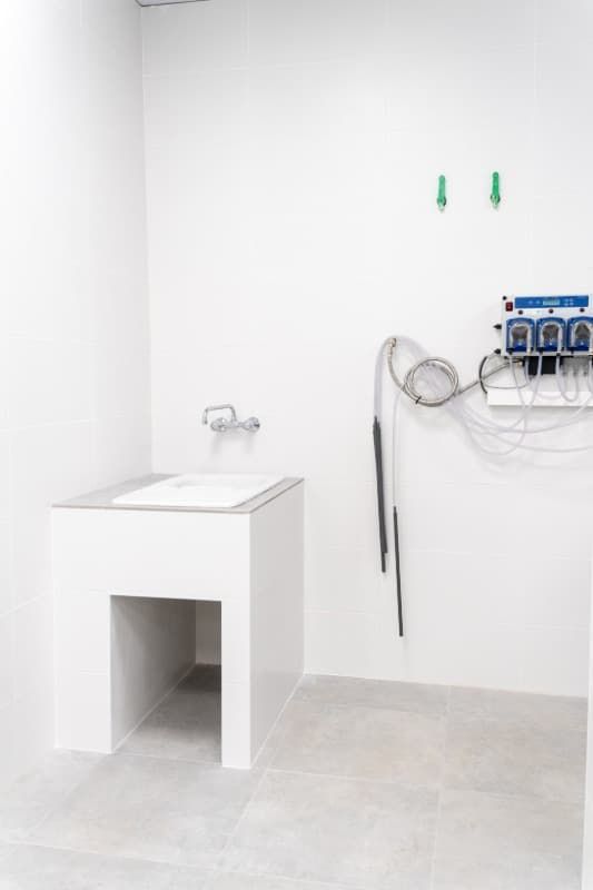 Lavabo de laboratorio blanco en una habitación completamente blanca con equipos.