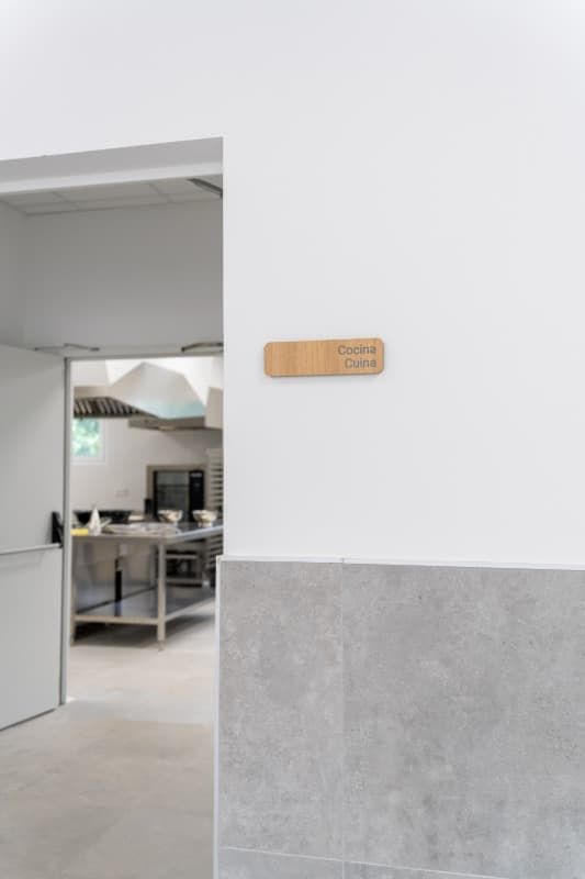 Pared blanca con un letrero de madera que dice