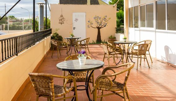 Hay muchas mesas y sillas en el balcón.