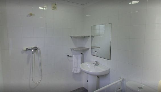 Un baño con lavabo, inodoro, ducha y espejo.