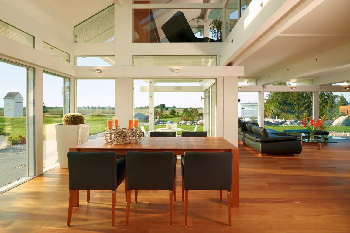 Ein Esszimmer mit Tisch und Stühlen und vielen Fenstern