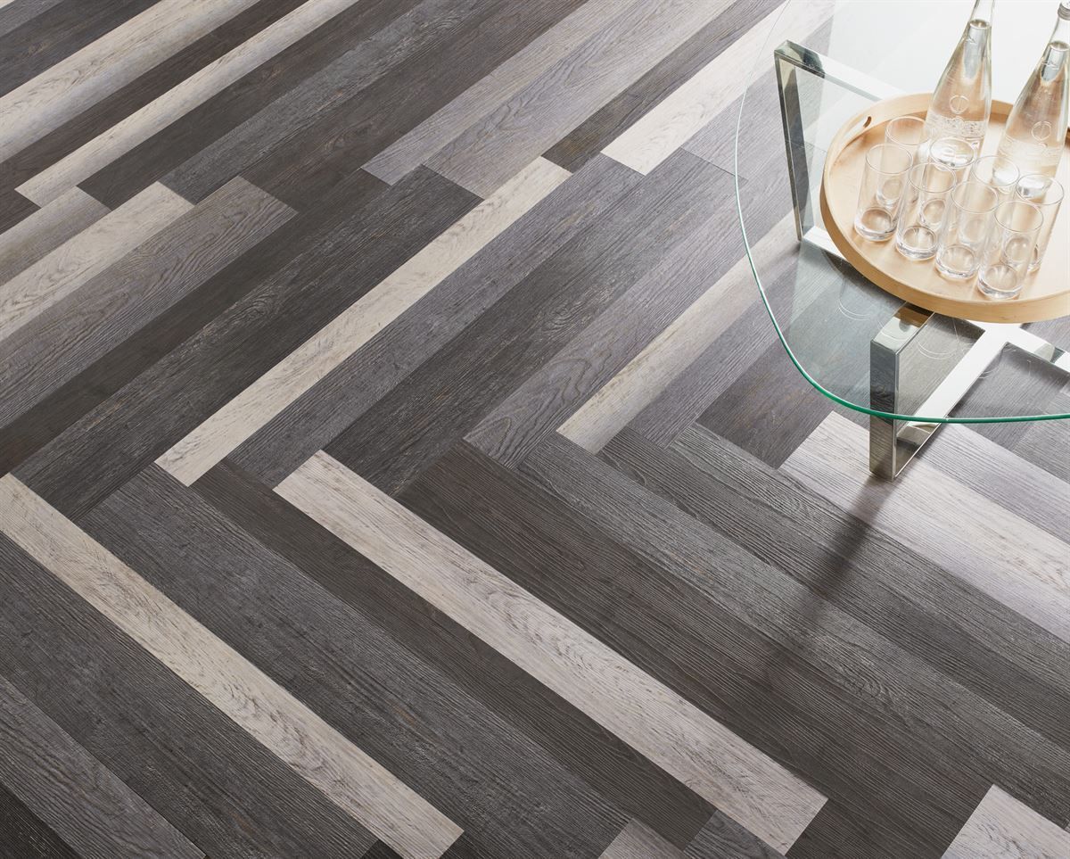 Ein Holzboden mit einem Glastisch und einem Tablett mit Weingläsern darauf.