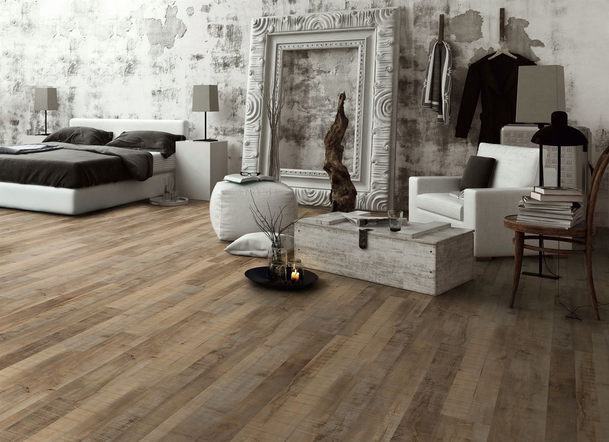 Ein Schlafzimmer mit Holzboden, einem Bett, einem Stuhl und einem Kamin.