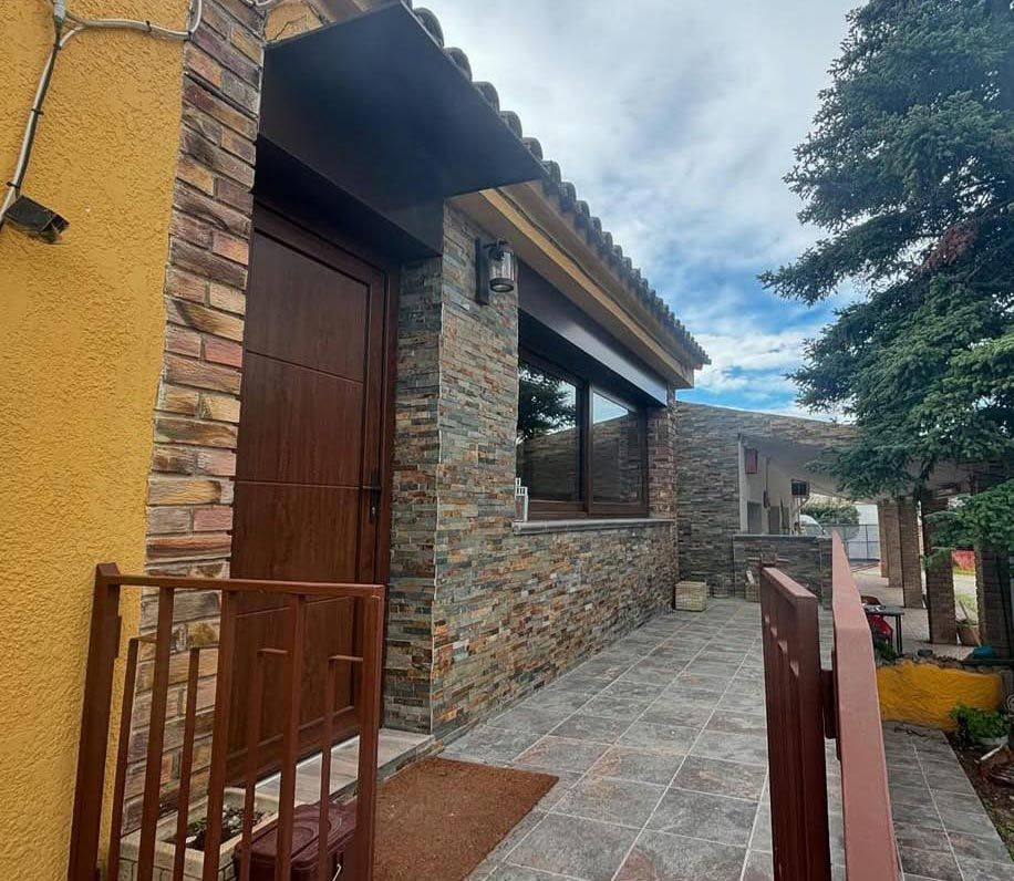 Un edificio amarillo con una pared de ladrillos y una puerta de madera.