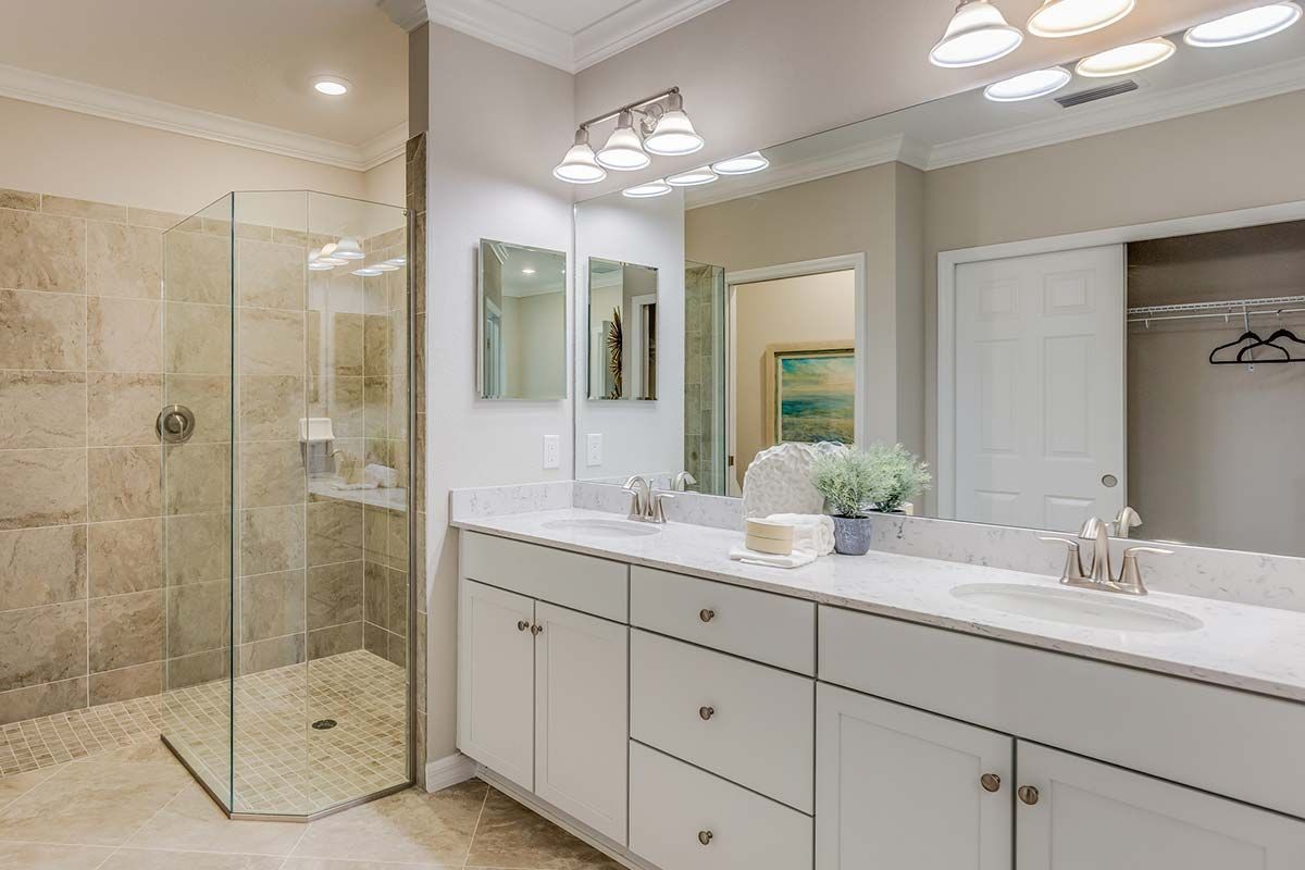 Un baño con dos lavabos y ducha.