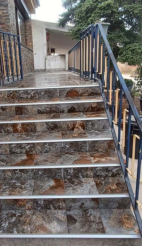 Un conjunto de escaleras con barandilla de metal que conducen a un edificio.