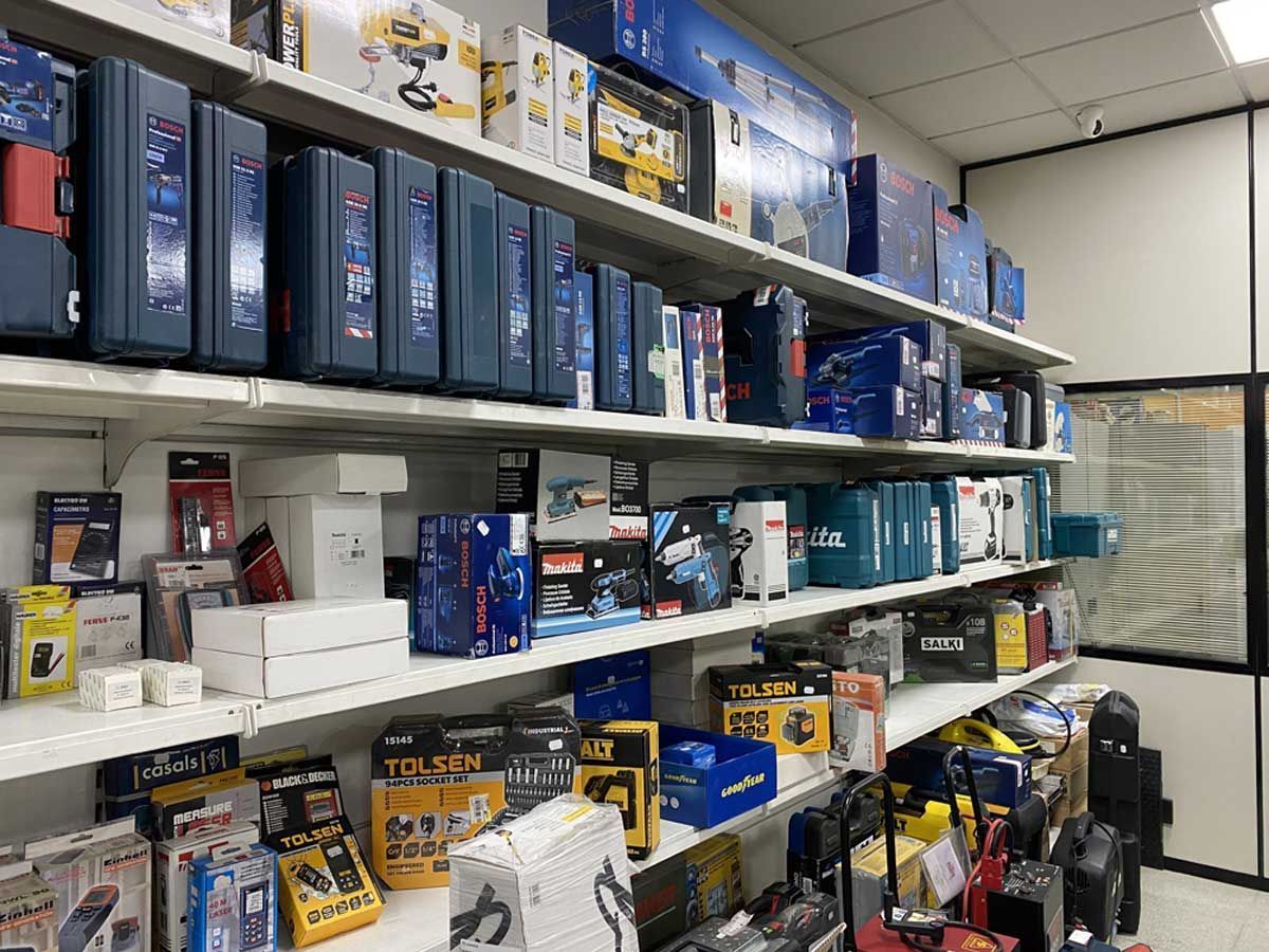 Estanterías de una tienda minorista repletas de diversas herramientas eléctricas, maletines para equipos y productos de ferretería.