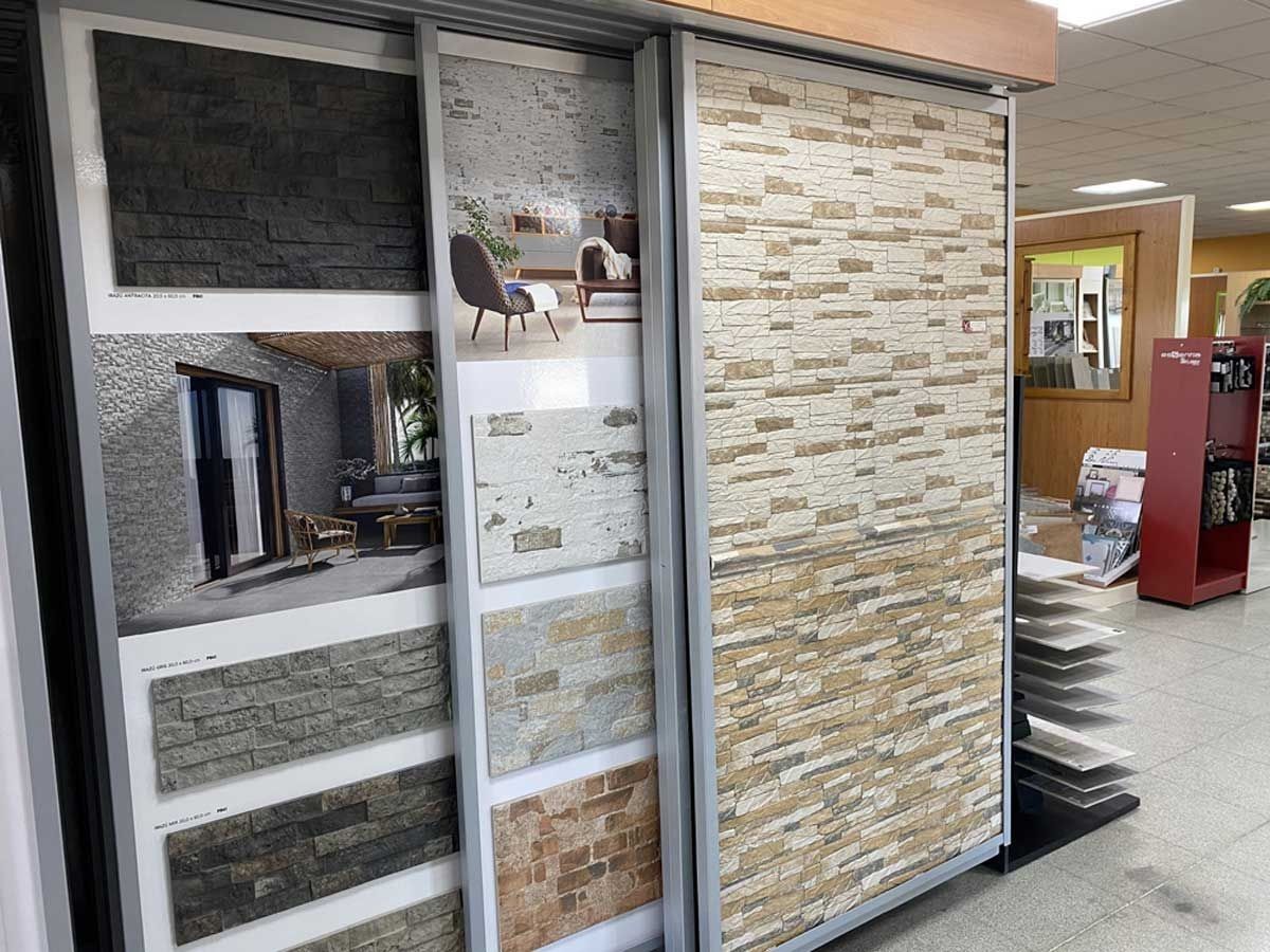 Una exposición que muestra diversas muestras de baldosas de revestimiento de piedra en diferentes texturas y tonos tierra.