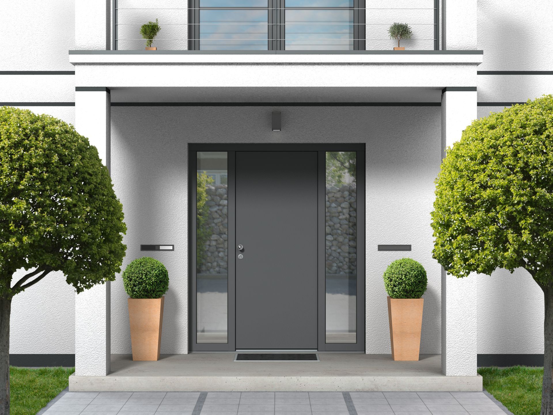 Entrée de maison moderne avec double porte grise, plantes en pot et arbustes taillés.
