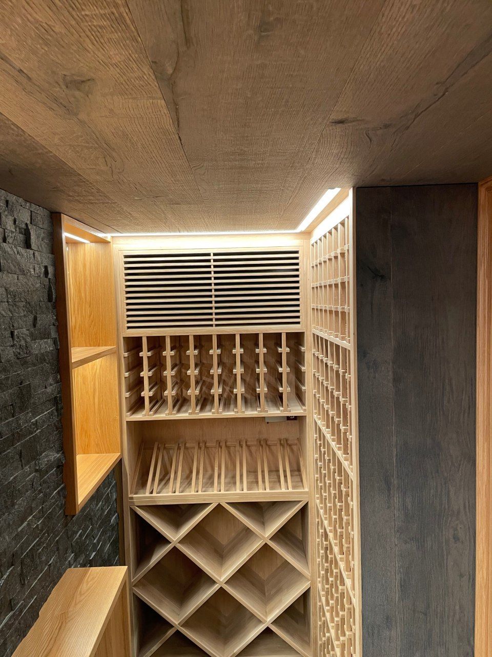 Une cave à vin avec de nombreuses étagères et bouteilles de vin.