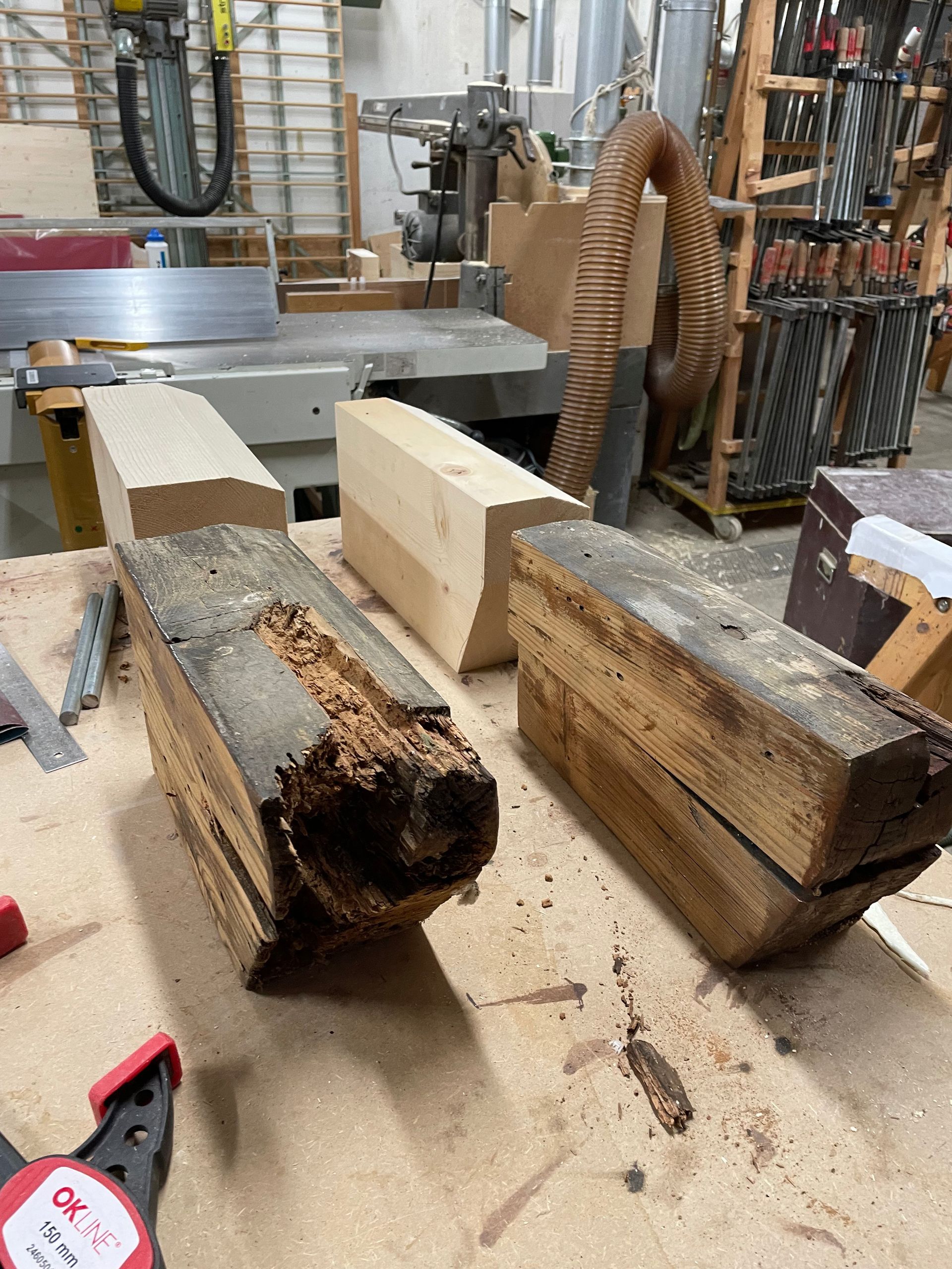 Deux morceaux de bois sont posés sur une table dans un atelier.