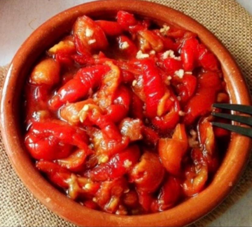 Un tazón de pimientos rojos con un tenedor dentro
