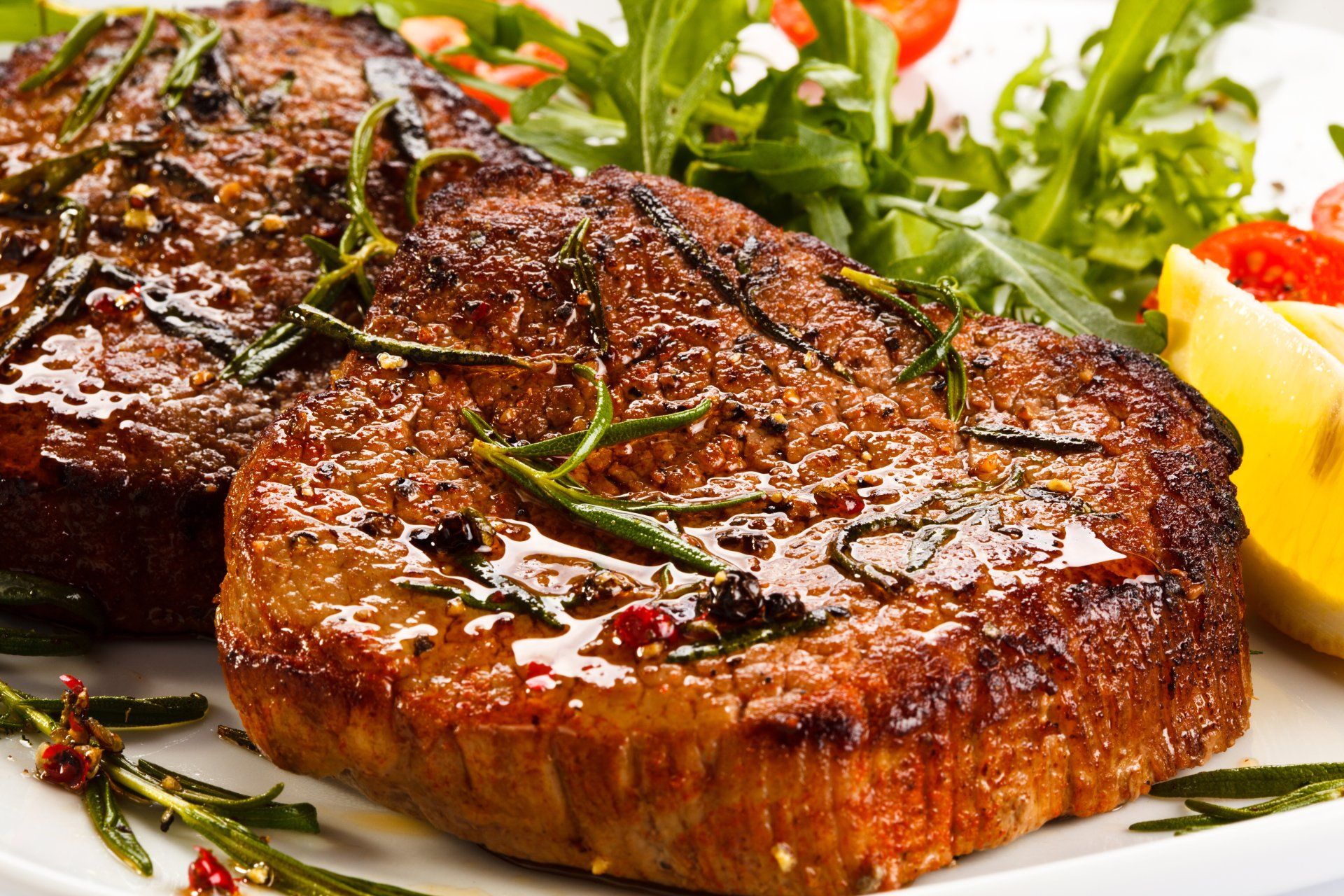 Un primer plano de un filete en un plato con verduras.