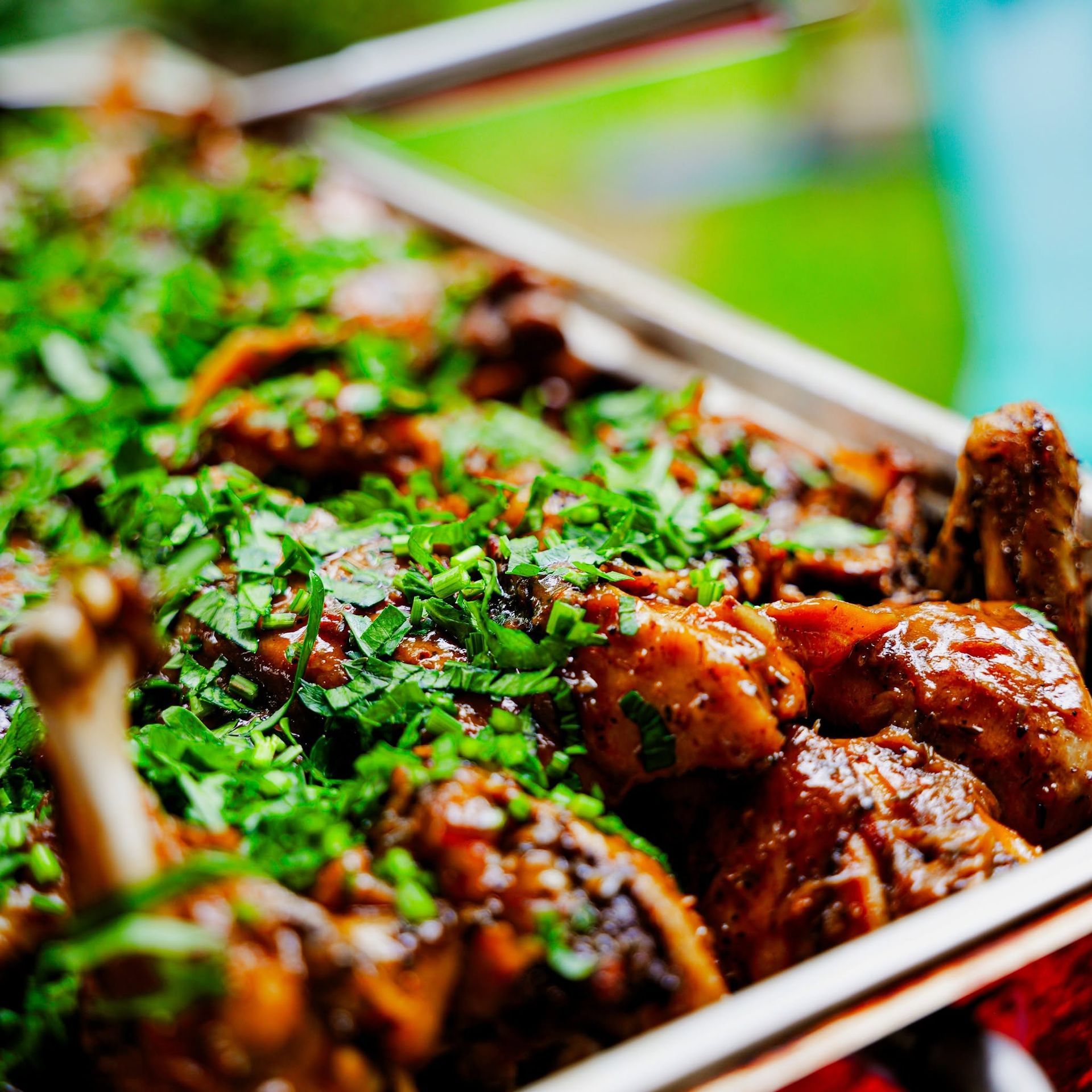Plat de viande glacée parsemée d’herbes vertes hachées, servi lors d’un buffet